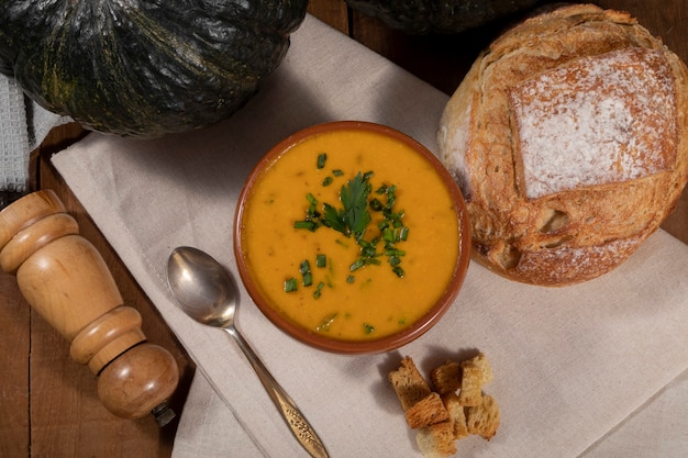 Pumpkin broth on wooden background.