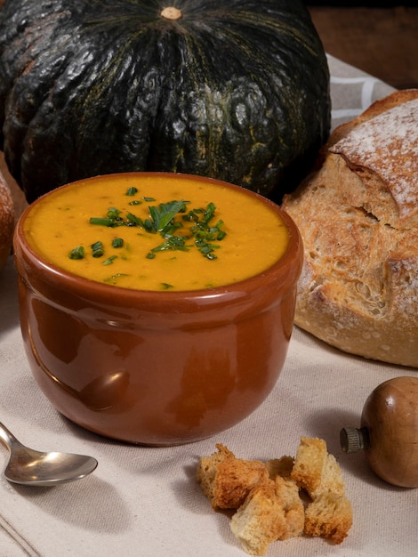 Pumpkin broth on wooden background.