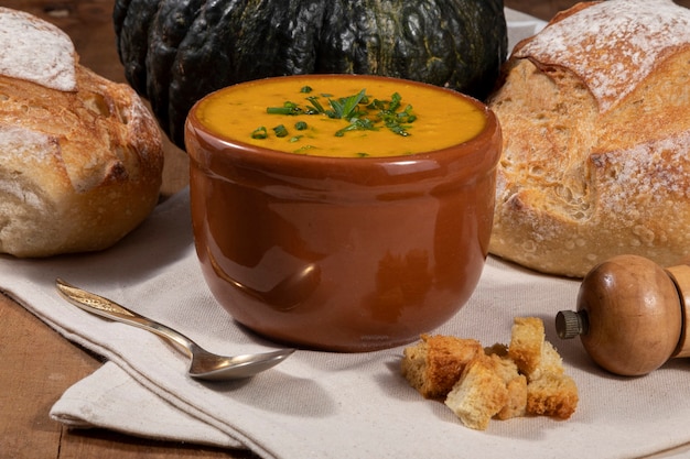 Pumpkin broth on wooden background.