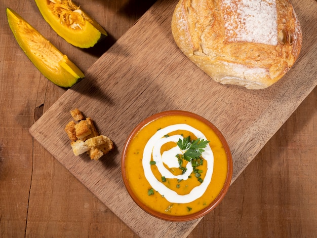 Pumpkin broth on wooden background.