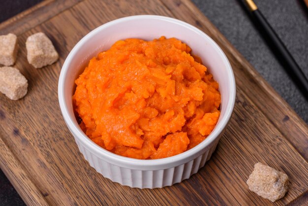 Pumpkin carrot baby puree in bowl on a dark background top view Fresh orange squash vegetable pumpkin carrot puree