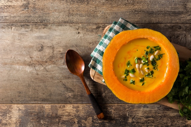 pumpkin and carrot soup on wooden table.