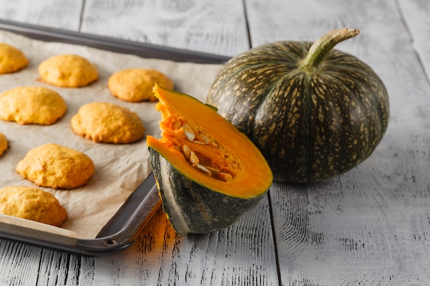 Pumpkin cookies on wooden table with pumpkins on a background