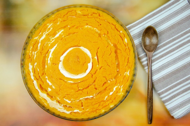 Pumpkin and cottage cheese casserole. round pumpkin sugar free diet pie, towel and wooden spoon on colorful background. festive pumpkin cheesecake. copy space, selective focus