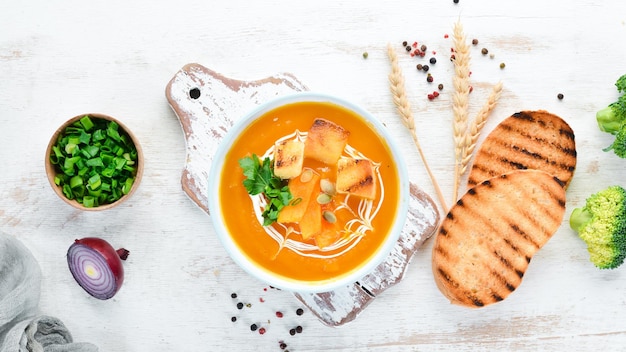 Pumpkin cream soup in a bowl with toast bread Dietary food Top view Free copy space