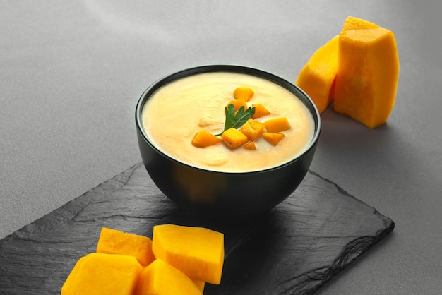 Pumpkin cream soup mashed potatoes on a gray background vegan curried pumpkin lentil soup puree in a