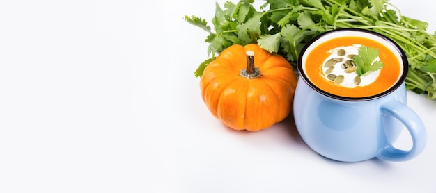 Pumpkin cream soup in a mug on a white background