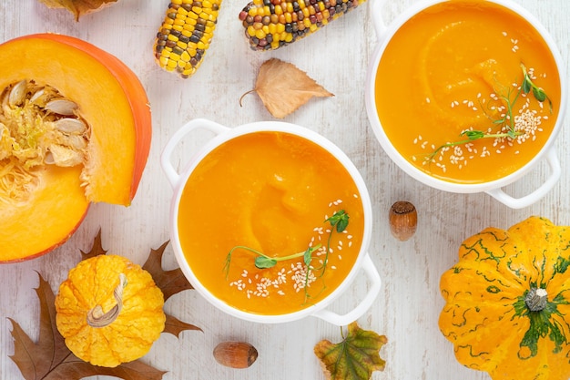 Pumpkin cream soup on white wooden background Directly above close up