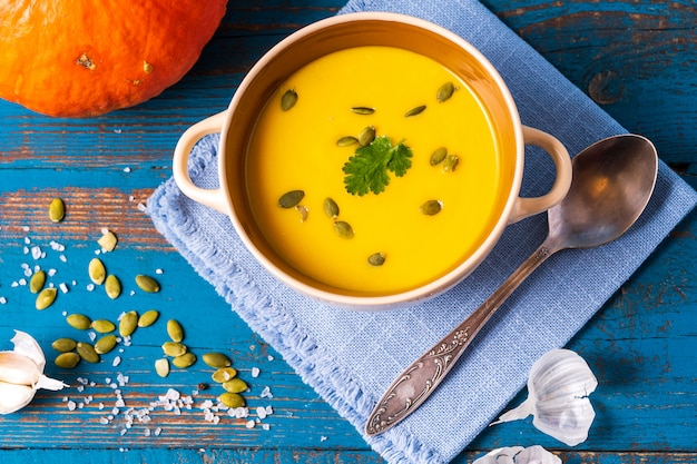 Photo pumpkin cream soup with pumpkin seeds served in a bowl.