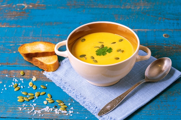 Pumpkin cream soup with pumpkin seeds served in a bowl.