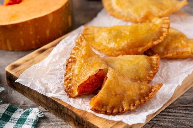 Pumpkin empanadillas on wooden table