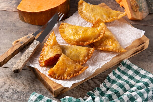 Pumpkin empanadillas on wooden table