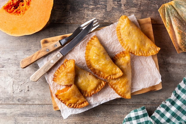 Pumpkin empanadillas on wooden table