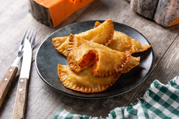 Pumpkin empanadillas on wooden table