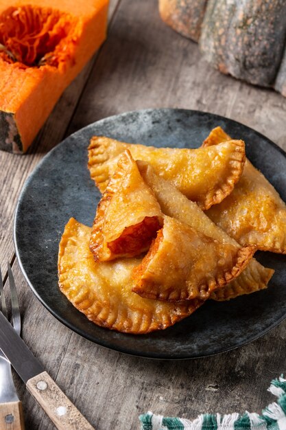 Pumpkin empanadillas on wooden table