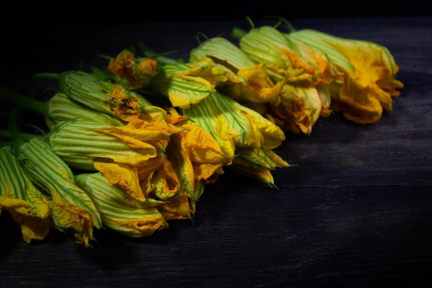 Foto fiori di zucca per cucinare su legno rustico