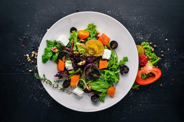 Pumpkin and fresh vegetables salad Italian cuisine Top view Free space for text On a wooden background