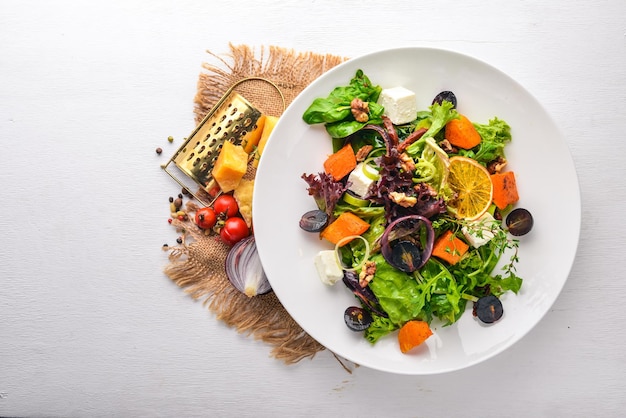 Insalata di zucca e verdure fresche cucina italiana vista dall'alto spazio libero per il testo su uno sfondo di legno