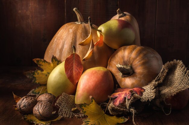 pumpkin and fruits in bulk on a dark wooden background in a rustic style