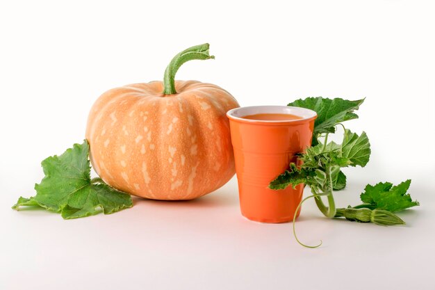 Pumpkin and a glass of pumpkin juice isolated on a white background