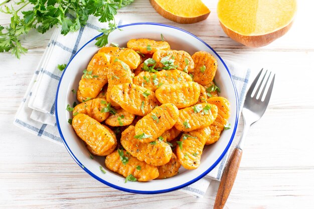 Pumpkin gnocchi with cheese and spices on the plate closeup, horizontal, top view