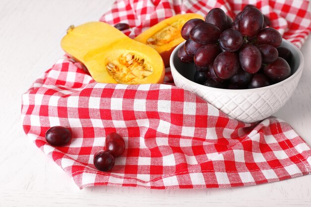 Pumpkin and grapes on table close up