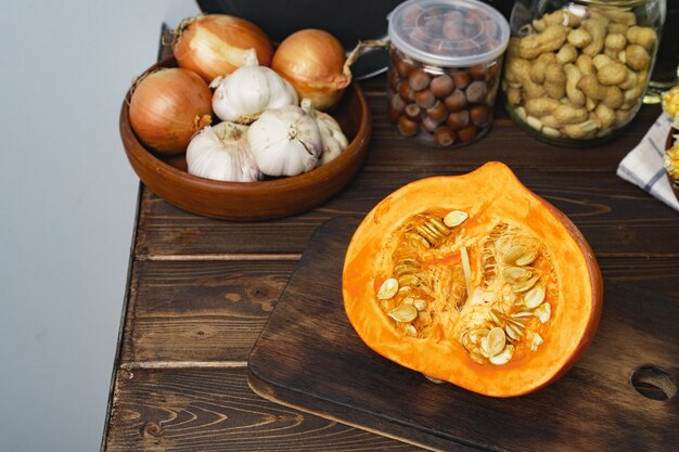 Pumpkin half on wooden board on kitchen table close up