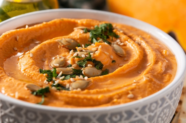 Pumpkin hummus and seeds on a wooden table