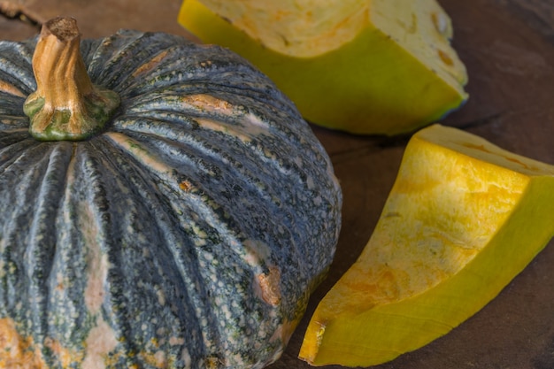 Pumpkin is a fresh vegetable have a green and yellow color on a wooden table