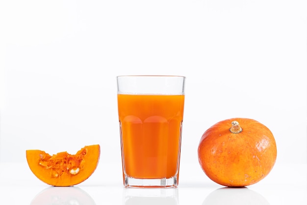 Pumpkin juice in transparent glass isolated on white background Vegetable vegetarian drink Healthy food and diet