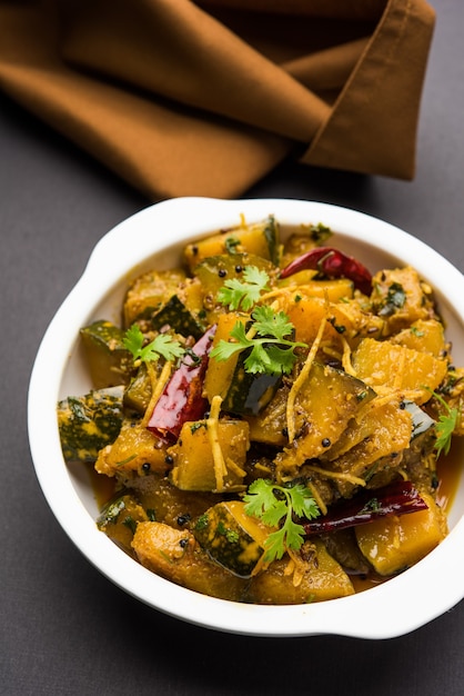 Pumpkin OR Kaddu ki Sabzi served in a bowl over moody background, selective focus