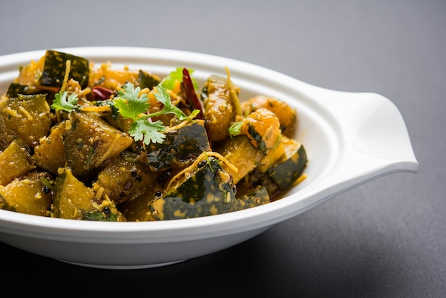 Pumpkin OR Kaddu ki Sabzi served in a bowl over moody background, selective focus