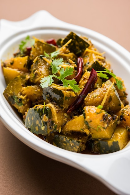 Pumpkin OR Kaddu ki Sabzi served in a bowl over moody background, selective focus