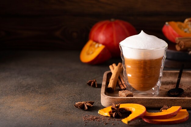 Pumpkin latte with cinnamon chocolate and honey on a wooden table