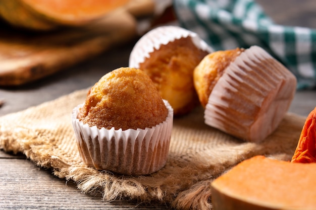 Pumpkin muffins on rustic wooden table. Autumn dessert