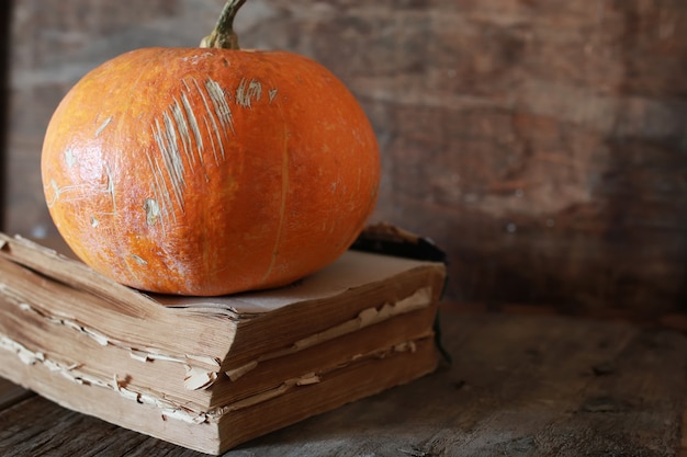 Pumpkin on old book and wooden background