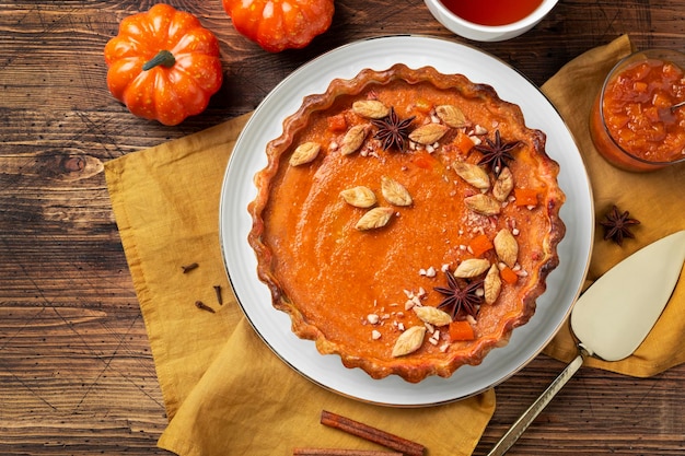 Pumpkin pie on a plate Wooden background Close up Top view