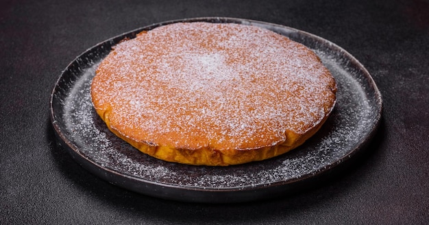 Pumpkin pie tart made for Thanksgiving day with whipped cream on a black plate