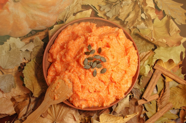 Pumpkin porridge with seeds on wooden table