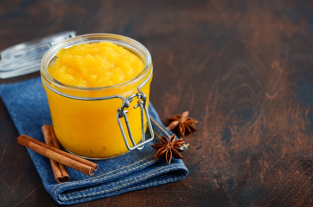 Pumpkin puree, confiture, jam, sauce with spices on a dark wooden table.