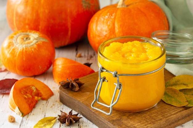 Pumpkin Puree with spices and Pumpkin on a wooden table