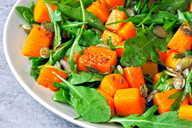 Pumpkin salad with arugula. Autumn salad with pumpkin and arugula. Vegan pumpkin salad.