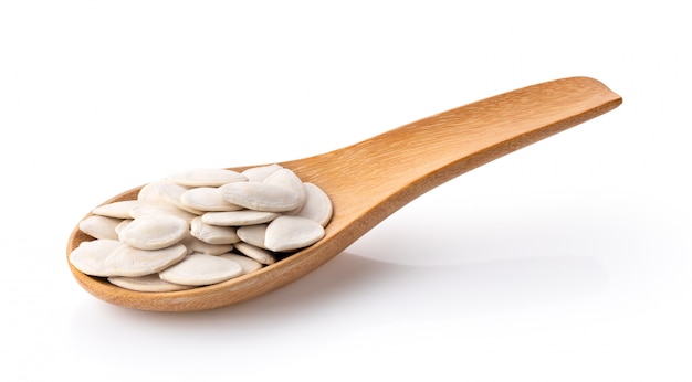 Pumpkin seed in wood spoon on white