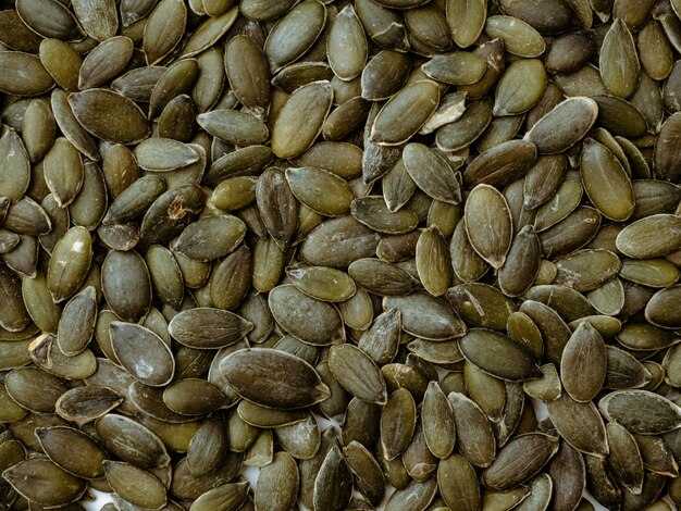 Pumpkin seeds background, top view