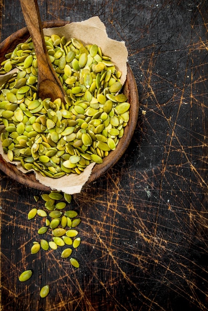 Pumpkin seeds in bowl with spoon