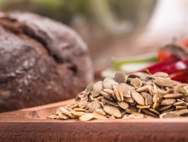 Pumpkin seeds close-up on a wooden plate