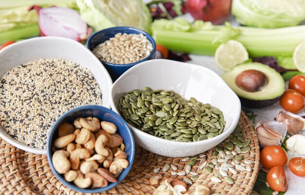 Pumpkin seeds nuts and chia seeds and other healthy foods on the kitchen table