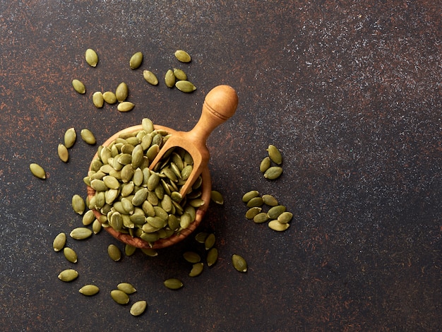 写真 茶色の背景にカボチャの種。上面図。