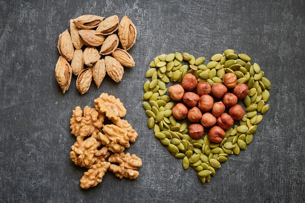 Pumpkin seeds or pepitas laid out in the shape of a heart and nuts