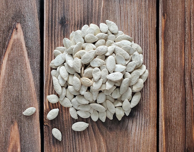 Pumpkin seeds roasted with salt on a wooden background, top view